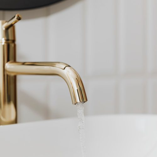 golden-faucet-with-running-water_53876-144977